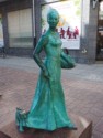 Statue of dog pulling on woman's dress
